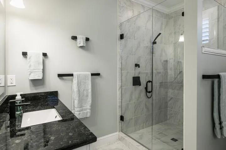 Small bathroom remodel with bright lighting, mirror, and light tile